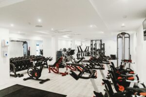 salle de sport avec diverses machines comme des vélos ou des poids